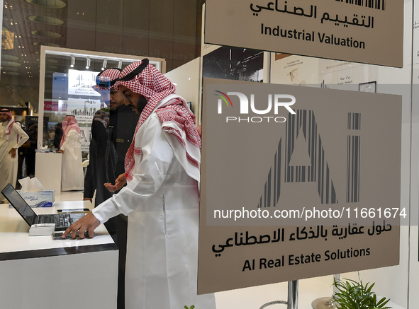 A salesman introduces a property to a potential buyer at the Cityscape Qatar 2024 real estate exhibition at the Doha Exhibition and Conventi...