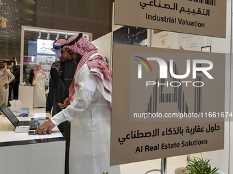 A salesman introduces a property to a potential buyer at the Cityscape Qatar 2024 real estate exhibition at the Doha Exhibition and Conventi...