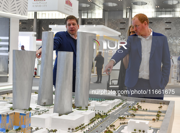 A salesman introduces property to potential buyers at the Cityscape Qatar 2024 real estate exhibition at the Doha Exhibition and Convention...