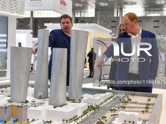 A salesman introduces property to potential buyers at the Cityscape Qatar 2024 real estate exhibition at the Doha Exhibition and Convention...