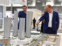 A salesman introduces property to potential buyers at the Cityscape Qatar 2024 real estate exhibition at the Doha Exhibition and Convention...