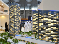 Visitors view models of a new building at the 'Cityscape Qatar 2024' real estate exhibition at the Doha Exhibition and Convention Center in...