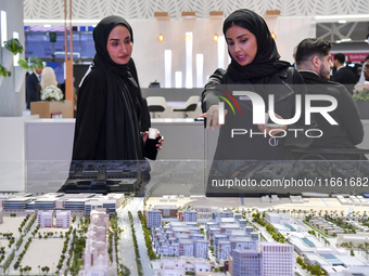 A saleswoman introduces property to a potential buyer at the Cityscape Qatar 2024 real estate exhibition at the Doha Exhibition and Conventi...