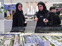 A saleswoman introduces property to a potential buyer at the Cityscape Qatar 2024 real estate exhibition at the Doha Exhibition and Conventi...