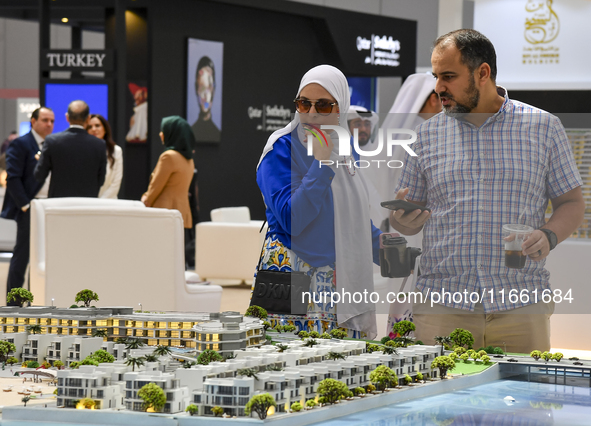 Visitors view models of a new building at the 'Cityscape Qatar 2024' real estate exhibition at the Doha Exhibition and Convention Center in...