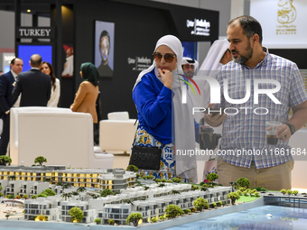 Visitors view models of a new building at the 'Cityscape Qatar 2024' real estate exhibition at the Doha Exhibition and Convention Center in...