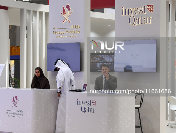 Visitors gather at the Qatar Invest pavilion at the Cityscape Qatar 2024 real estate exhibition at the Doha Exhibition and Convention Center...