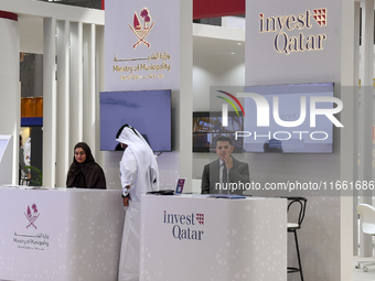 Visitors gather at the Qatar Invest pavilion at the Cityscape Qatar 2024 real estate exhibition at the Doha Exhibition and Convention Center...