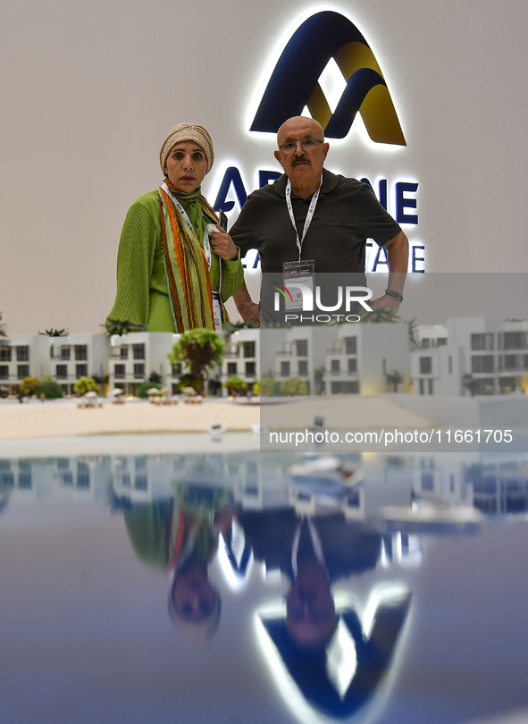 Visitors view models of a new building at the 'Cityscape Qatar 2024' real estate exhibition at the Doha Exhibition and Convention Center in...