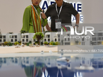 Visitors view models of a new building at the 'Cityscape Qatar 2024' real estate exhibition at the Doha Exhibition and Convention Center in...