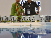 Visitors view models of a new building at the 'Cityscape Qatar 2024' real estate exhibition at the Doha Exhibition and Convention Center in...