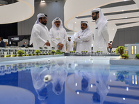 Visitors view models of a new building at the 'Cityscape Qatar 2024' real estate exhibition at the Doha Exhibition and Convention Center in...