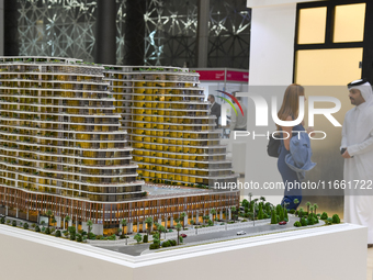 Visitors view models of a new building at the 'Cityscape Qatar 2024' real estate exhibition at the Doha Exhibition and Convention Center in...