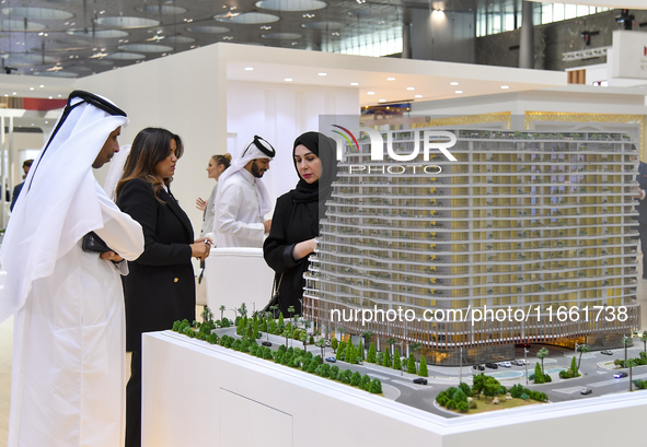 Visitors view models of a new building at the 'Cityscape Qatar 2024' real estate exhibition at the Doha Exhibition and Convention Center in...