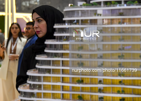 Visitors view models of a new building at the 'Cityscape Qatar 2024' real estate exhibition at the Doha Exhibition and Convention Center in...