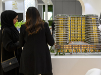 Visitors view models of a new building at the 'Cityscape Qatar 2024' real estate exhibition at the Doha Exhibition and Convention Center in...