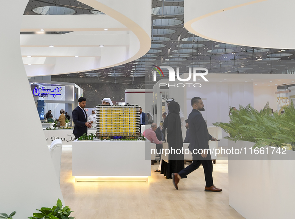 Visitors view models of a new building at the 'Cityscape Qatar 2024' real estate exhibition at the Doha Exhibition and Convention Center in...