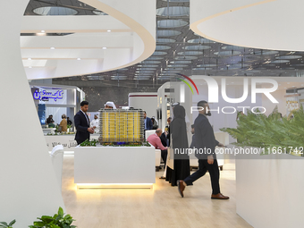 Visitors view models of a new building at the 'Cityscape Qatar 2024' real estate exhibition at the Doha Exhibition and Convention Center in...