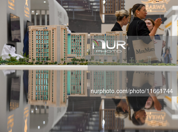 Visitors view models of a new building at the 'Cityscape Qatar 2024' real estate exhibition at the Doha Exhibition and Convention Center in...