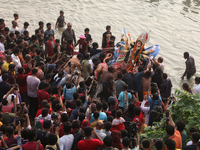 Bangladeshi Hindu devotees carry an idol of the Hindu Goddess Durga to immerse in the Buriganga River during the final day of the Durga Puja...