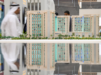 Visitors view models of a new building at the 'Cityscape Qatar 2024' real estate exhibition at the Doha Exhibition and Convention Center in...