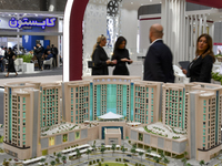 Visitors view models of a new building at the 'Cityscape Qatar 2024' real estate exhibition at the Doha Exhibition and Convention Center in...