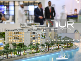 Visitors view models of a new building at the 'Cityscape Qatar 2024' real estate exhibition at the Doha Exhibition and Convention Center in...