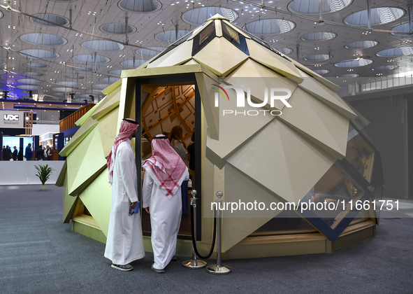 Visitors view models of a new building at the 'Cityscape Qatar 2024' real estate exhibition at the Doha Exhibition and Convention Center in...