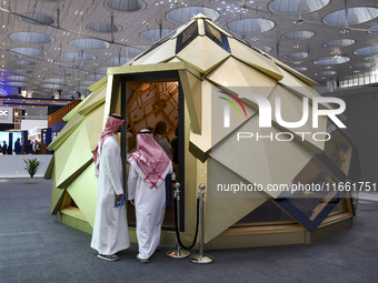 Visitors view models of a new building at the 'Cityscape Qatar 2024' real estate exhibition at the Doha Exhibition and Convention Center in...