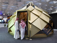 Visitors view models of a new building at the 'Cityscape Qatar 2024' real estate exhibition at the Doha Exhibition and Convention Center in...