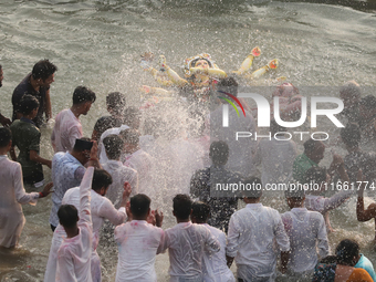 Bangladeshi Hindu devotees carry an idol of the Hindu Goddess Durga to immerse in the Buriganga River during the final day of the Durga Puja...