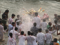 Bangladeshi Hindu devotees carry an idol of the Hindu Goddess Durga to immerse in the Buriganga River during the final day of the Durga Puja...