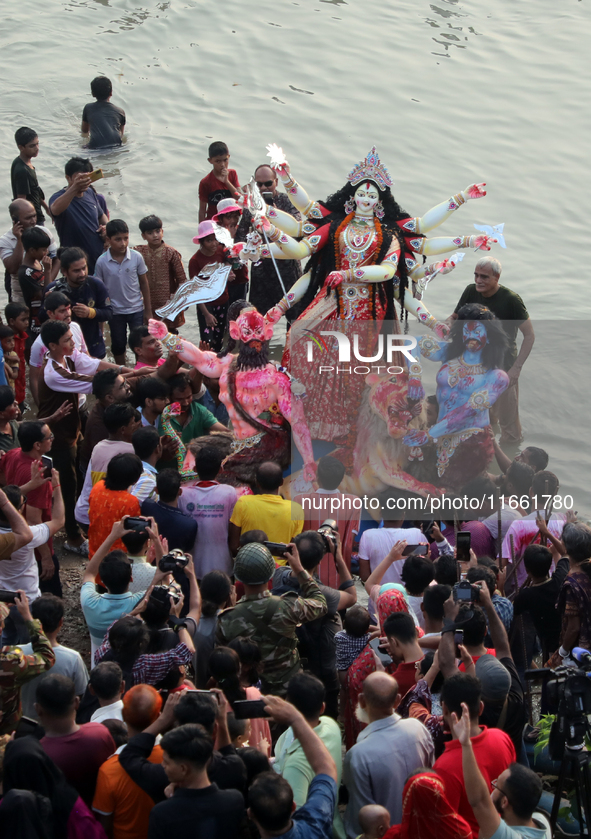 Bangladeshi Hindu devotees carry an idol of the Hindu Goddess Durga to immerse in the Buriganga River during the final day of the Durga Puja...