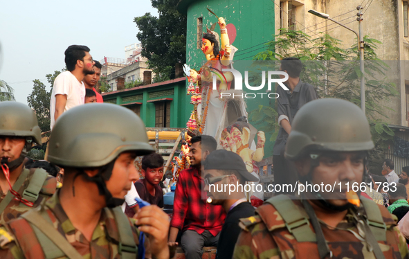 Bangladeshi Hindu devotees carry an idol of the Hindu Goddess Durga to immerse in the Buriganga River during the final day of the Durga Puja...