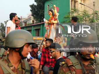 Bangladeshi Hindu devotees carry an idol of the Hindu Goddess Durga to immerse in the Buriganga River during the final day of the Durga Puja...