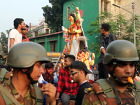 Bangladeshi Hindu devotees carry an idol of the Hindu Goddess Durga to immerse in the Buriganga River during the final day of the Durga Puja...