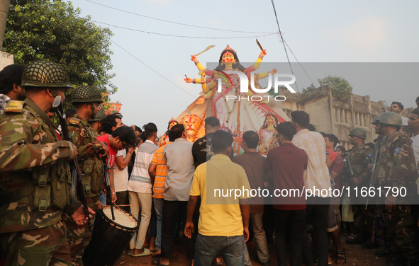 Bangladeshi Hindu devotees carry an idol of the Hindu Goddess Durga to immerse in the Buriganga River during the final day of the Durga Puja...