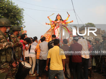 Bangladeshi Hindu devotees carry an idol of the Hindu Goddess Durga to immerse in the Buriganga River during the final day of the Durga Puja...