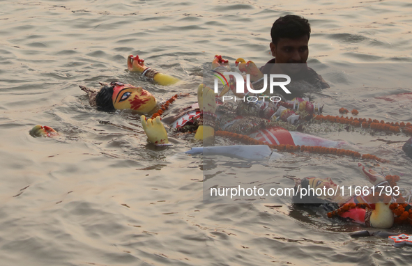 Bangladeshi Hindu devotees carry an idol of the Hindu Goddess Durga to immerse in the Buriganga River during the final day of the Durga Puja...