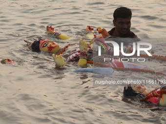 Bangladeshi Hindu devotees carry an idol of the Hindu Goddess Durga to immerse in the Buriganga River during the final day of the Durga Puja...