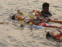 Bangladeshi Hindu devotees carry an idol of the Hindu Goddess Durga to immerse in the Buriganga River during the final day of the Durga Puja...