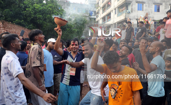 Bangladeshi Hindu devotees carry an idol of the Hindu Goddess Durga to immerse in the Buriganga River during the final day of the Durga Puja...