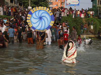 Bangladeshi Hindu devotees immerse an idol of their deity Durga into the Buriganga River during celebrations on the last day of the Durga Pu...