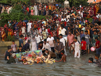 Bangladeshi Hindu devotees immerse an idol of their deity Durga into the Buriganga River during celebrations on the last day of the Durga Pu...