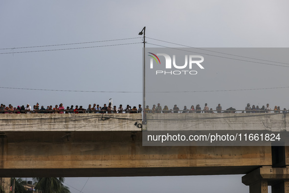 Bangladeshi Hindu devotees immerse an idol of their deity Durga into the Buriganga River during celebrations on the last day of the Durga Pu...