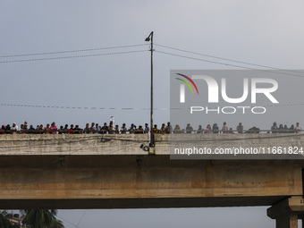 Bangladeshi Hindu devotees immerse an idol of their deity Durga into the Buriganga River during celebrations on the last day of the Durga Pu...