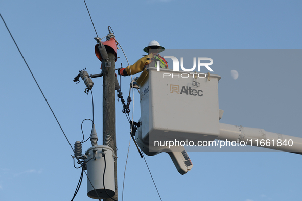 Utility workers supervised by Florida Power and Light work on a transformer in Punta Gorda, Florida, on October 12, 2024. Hurricane Milton m...