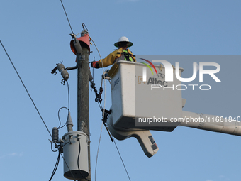 Utility workers supervised by Florida Power and Light work on a transformer in Punta Gorda, Florida, on October 12, 2024. Hurricane Milton m...