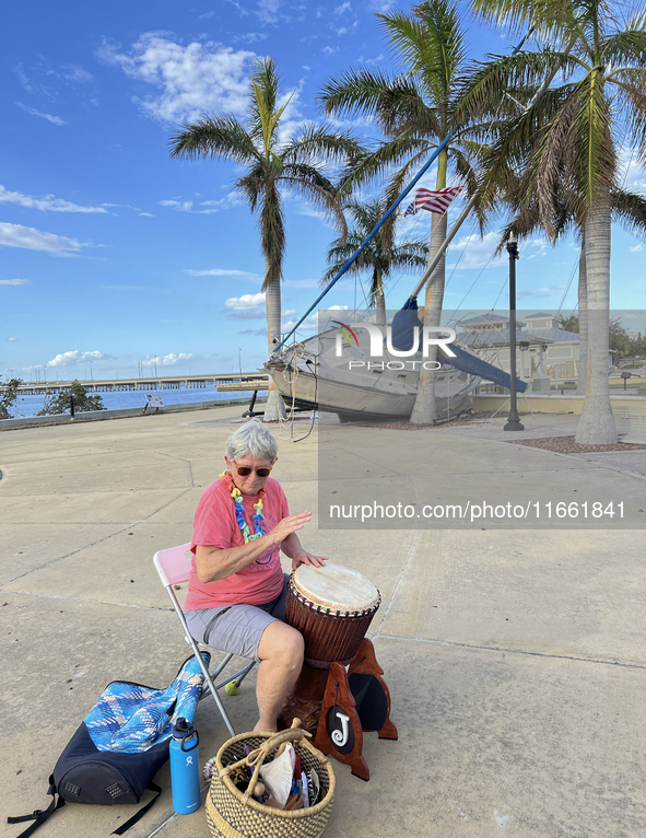 Jane Kerstetter arrives early for a drum circle at Gilchrist Park in Punta Gorda, Florida, on October 12, 2024. A sailboat sits in the backg...