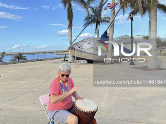 Jane Kerstetter arrives early for a drum circle at Gilchrist Park in Punta Gorda, Florida, on October 12, 2024. A sailboat sits in the backg...